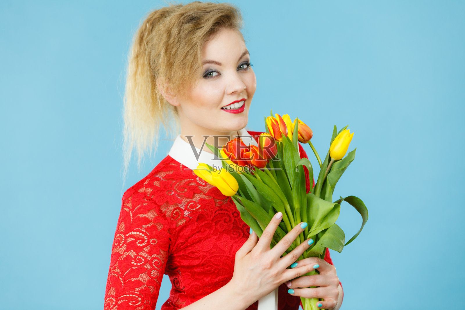 漂亮的女人用红色的黄色郁金香束照片摄影图片