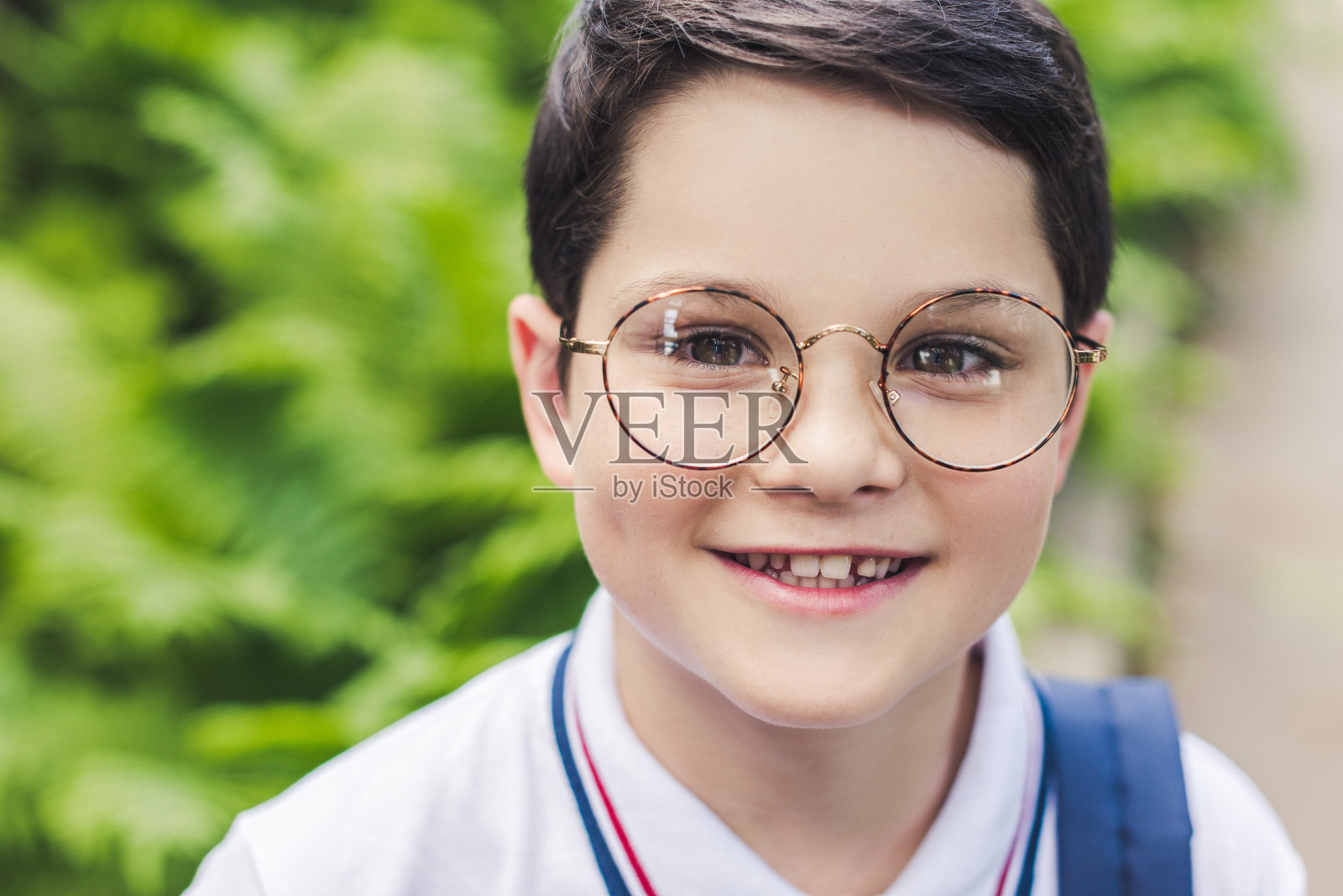 特写的快乐的孩子在圆形眼镜看相机照片摄影图片