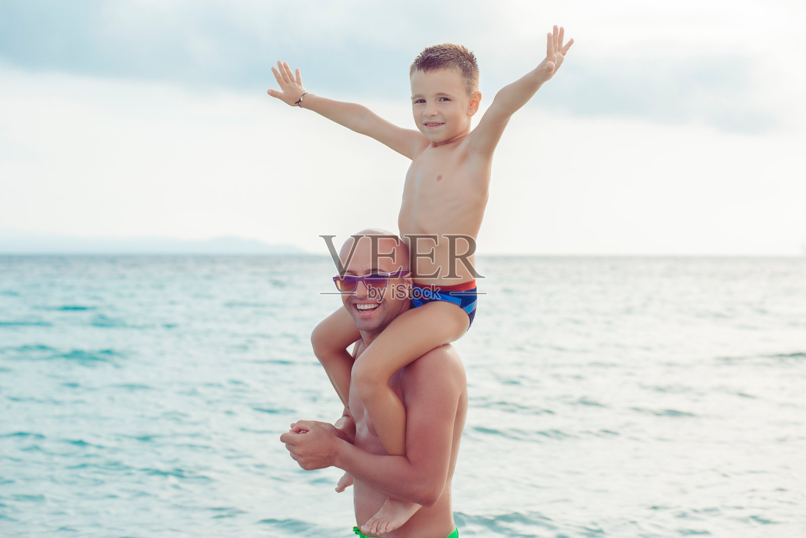 父亲和儿子在水里玩照片摄影图片