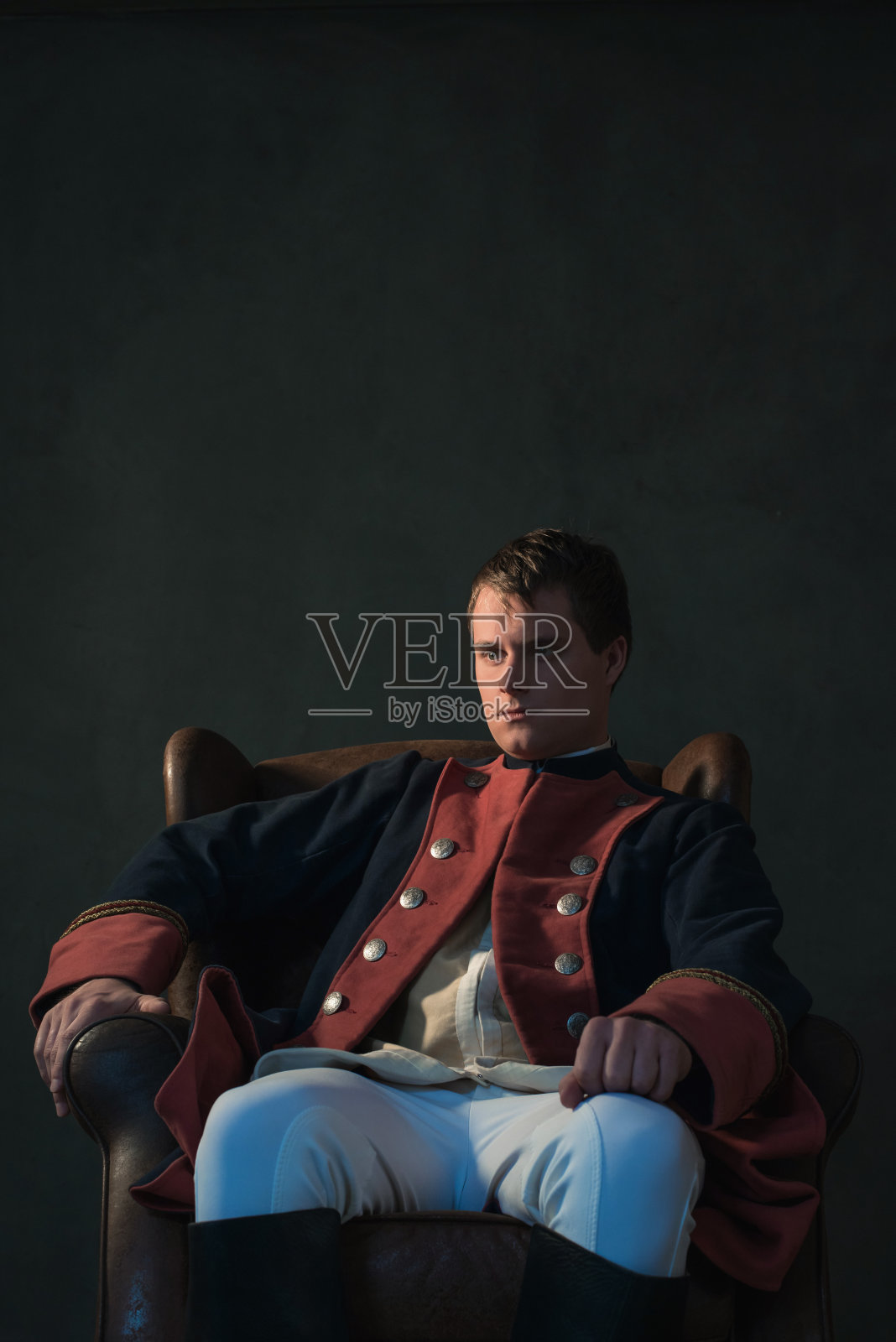 坐在椅子上的帝国风格的男人。照片摄影图片