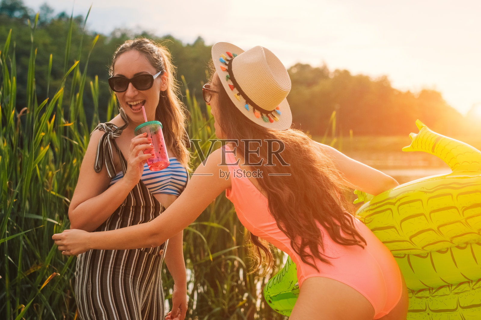 两个女人在湖边欣赏日落照片摄影图片