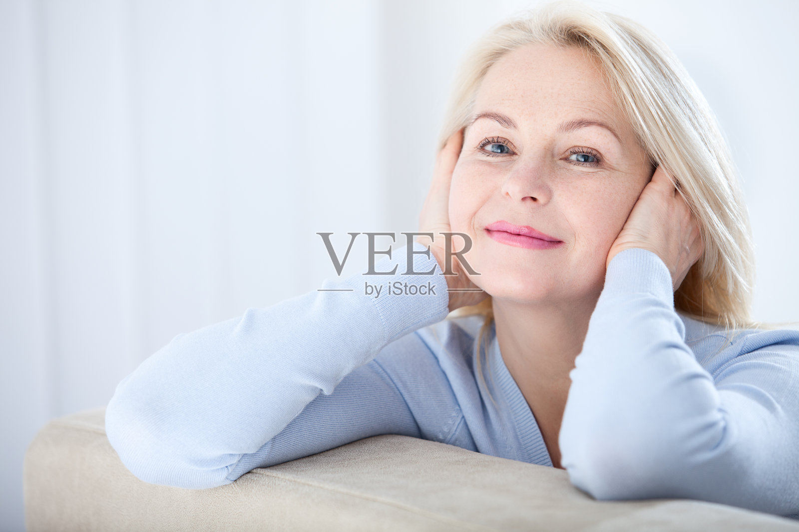 活跃美丽的中年妇女微笑友好，看着镜头。女人的脸特写镜头。逼真的图像，没有修饰自己的缺陷。有选择性的重点。照片摄影图片