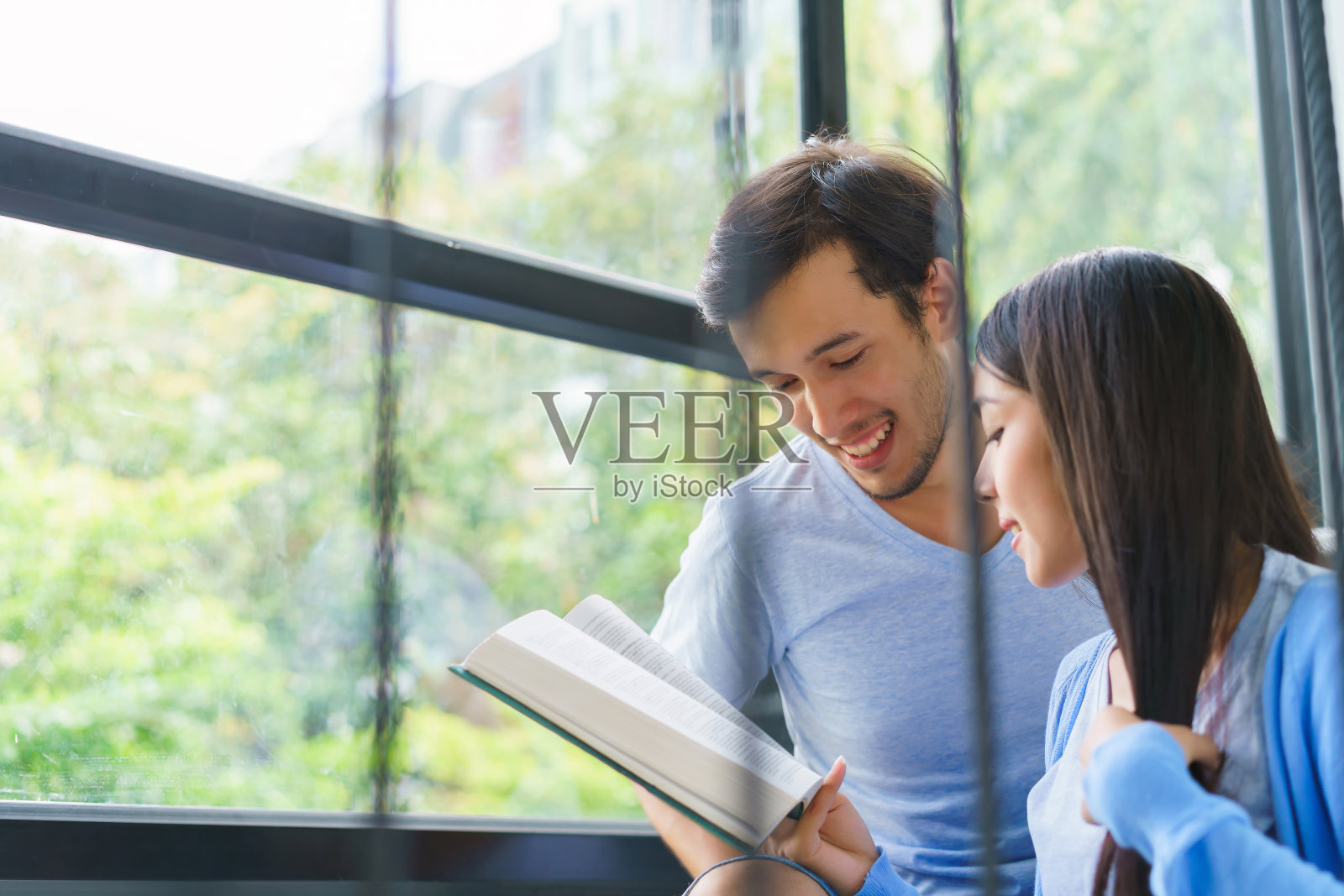 两名学生在一所大学的室内看着你。照片摄影图片