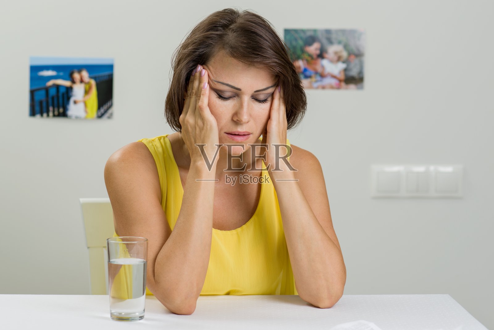 强调伤心的女人。她双手抱着头。照片摄影图片