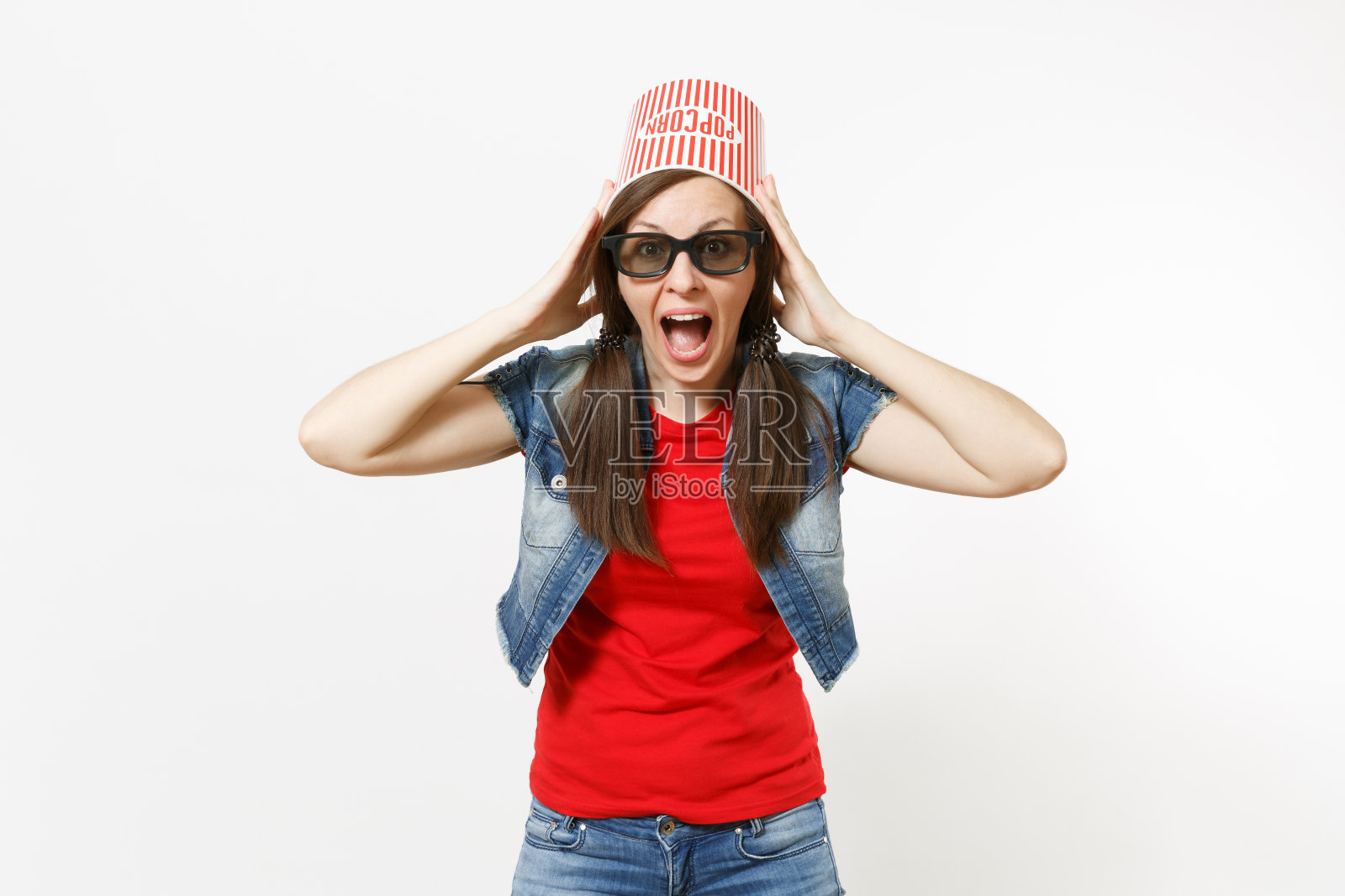 年轻的震惊有吸引力的女人的肖像在3d眼镜和休闲衣服桶爆米花在头上看电影电影和坚持头孤立在白色的背景。情感电影。照片摄影图片