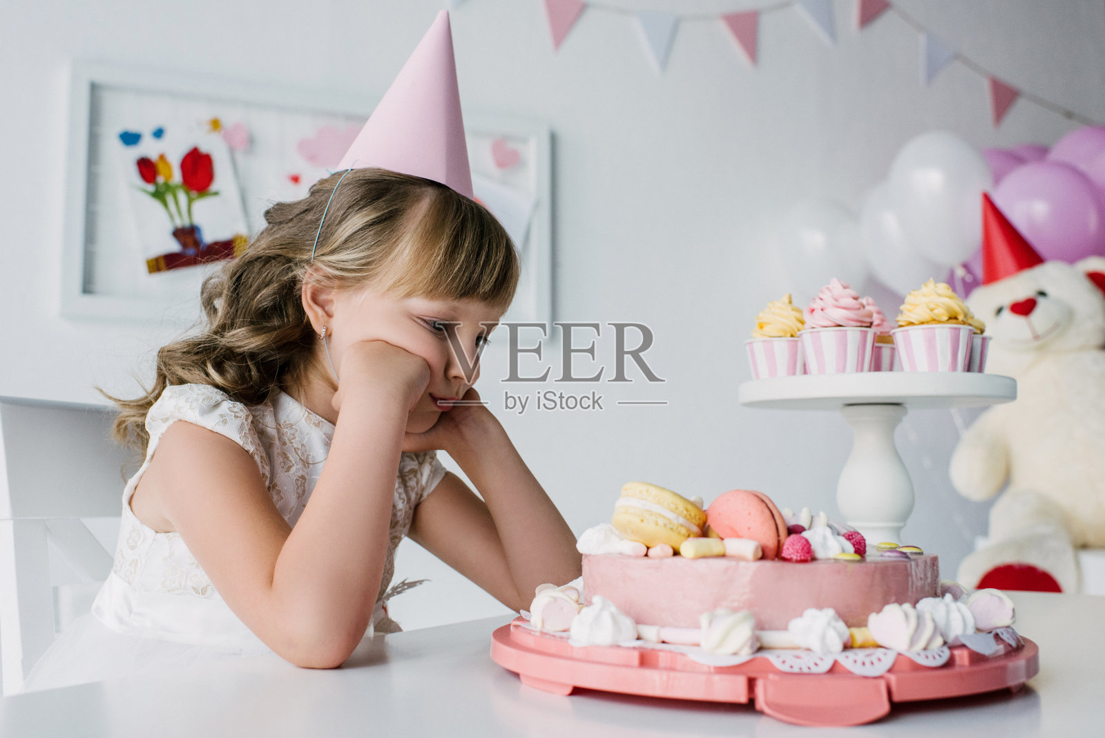 心烦意乱的孤独的孩子坐在桌子上吃生日蛋糕照片摄影图片