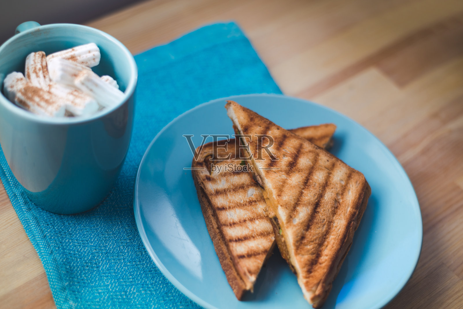 在蓝色的盘子上烤面包。早餐三明治。照片摄影图片