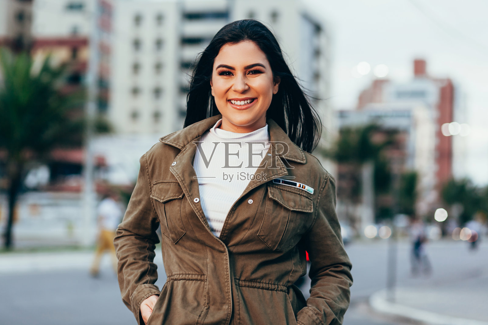 穿着夹克的年轻女子在城市户外的肖像照片摄影图片