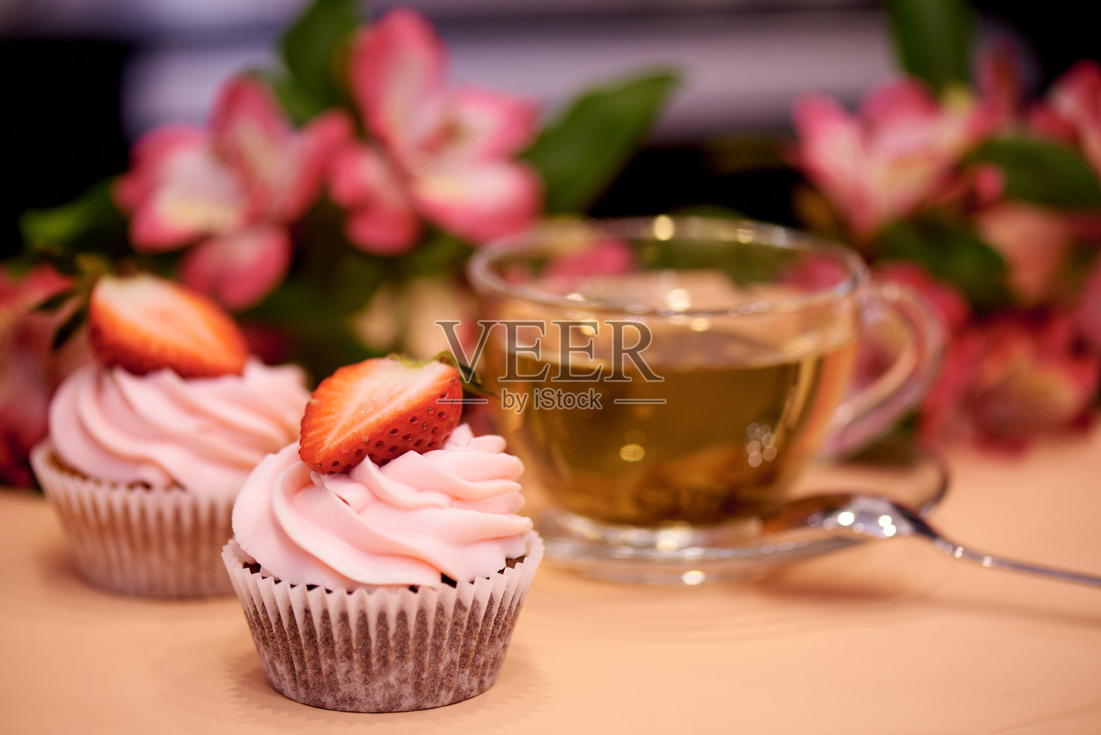 草莓巧克力纸杯蛋糕。小蛋糕配一杯茶。有选择性的重点。照片摄影图片