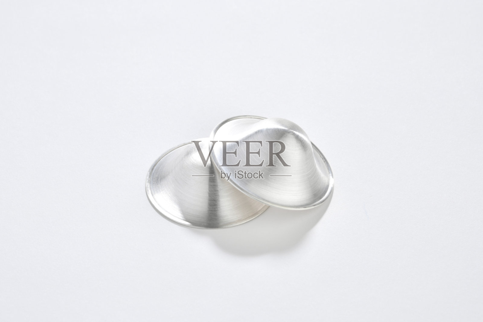 银色乳头护盾，舒适的母乳喂养在白色的背景照片摄影图片