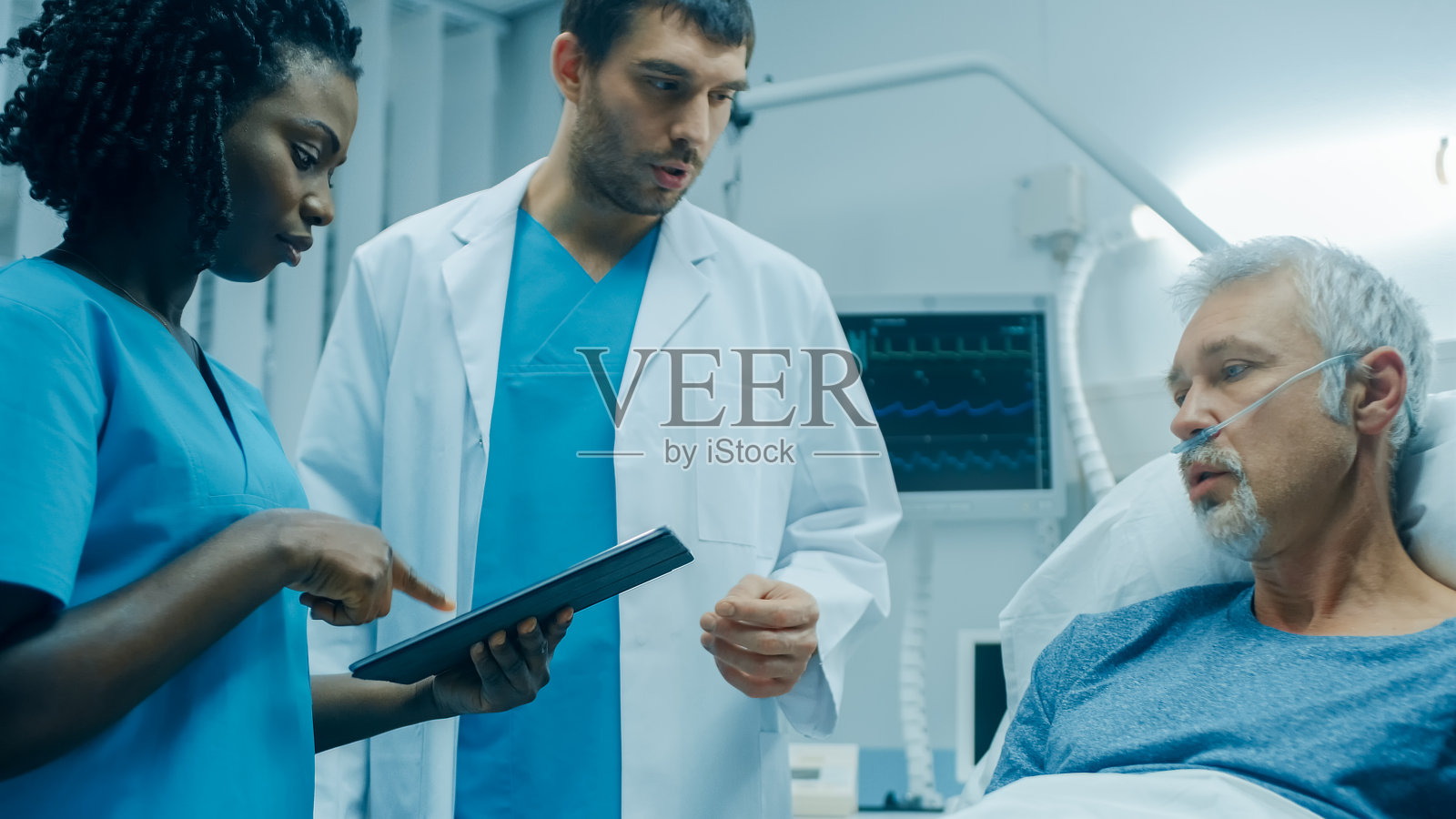 医院里，老男人躺在床上，与使用平板电脑的医生和护士交谈。科技帮助治愈病人，现代医院病房。照片摄影图片