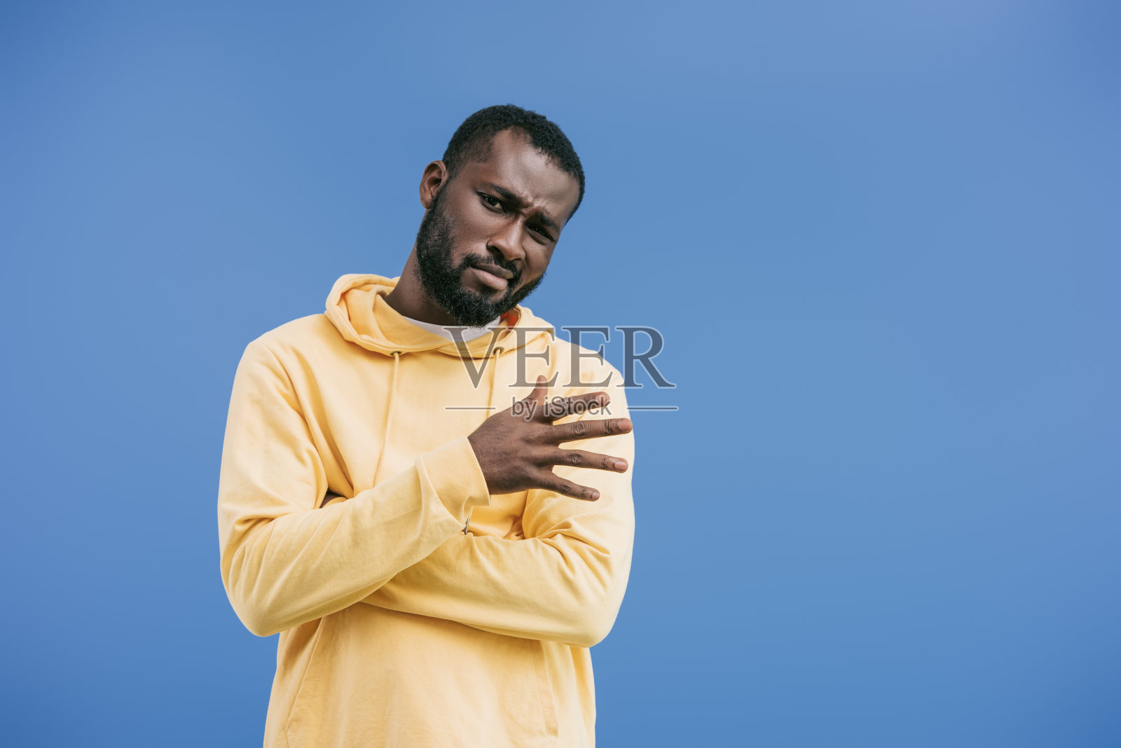 怀疑的年轻非洲裔美国人用手示意孤立在蓝色背景照片摄影图片