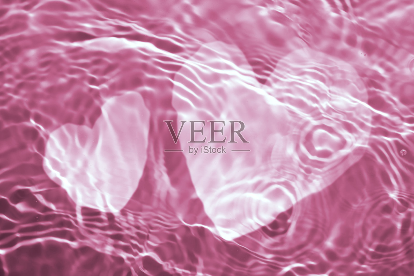 粉红色液体化妆品水凝胶上的心形与圆形波纹效果照片摄影图片