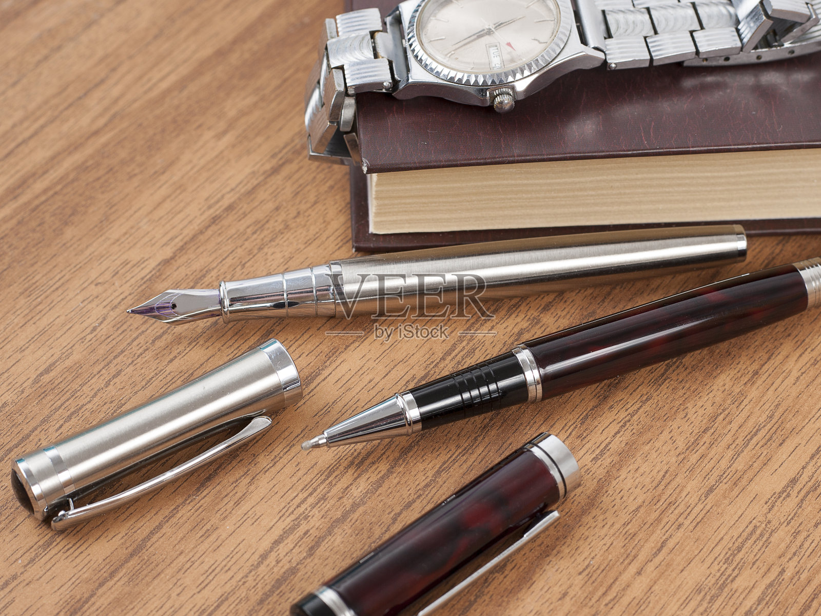 笔记本，钢笔和手表放在木桌上照片摄影图片