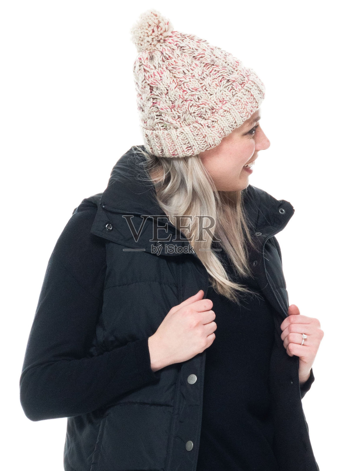 白种年轻女子身着夹克无袖站在白色背景前照片摄影图片