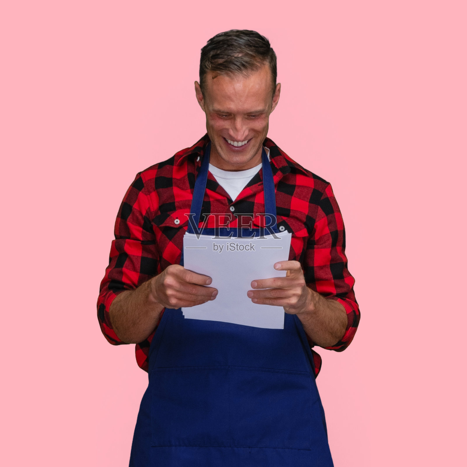 白人男性站在有色背景穿着格子衬衫和持有文件照片摄影图片