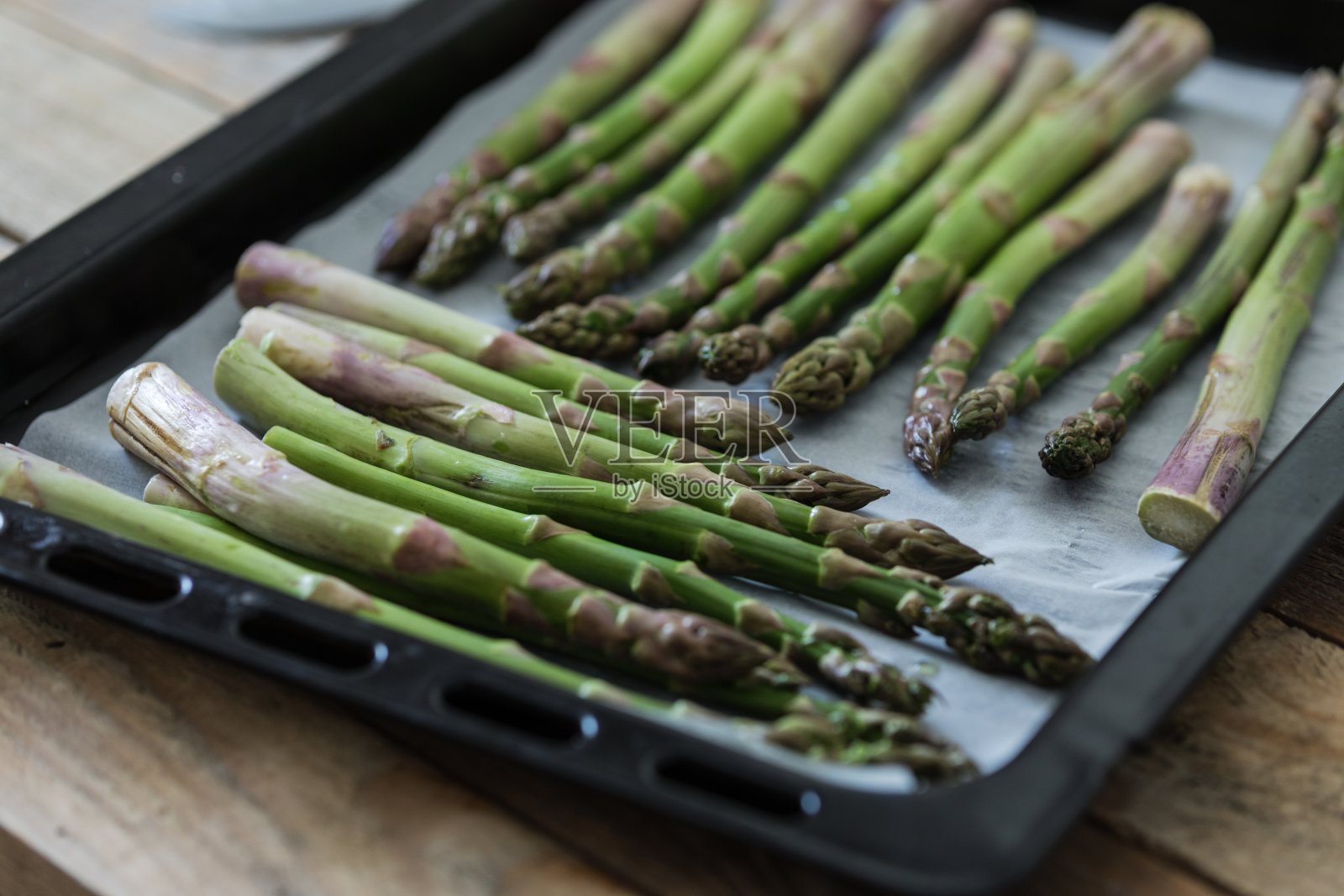 芦笋芽放在烤盘上照片摄影图片