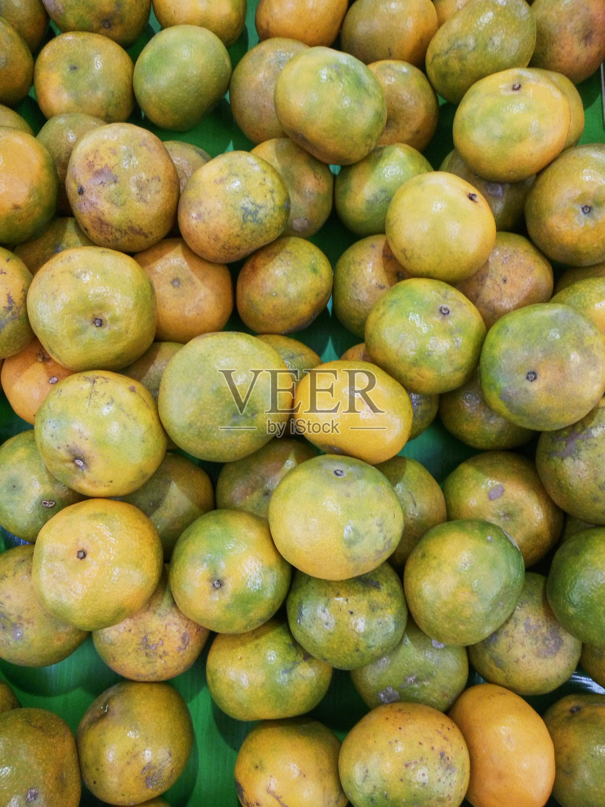 橙子，亚洲热带地区特有的水果，堆放在超市的篮子里照片摄影图片