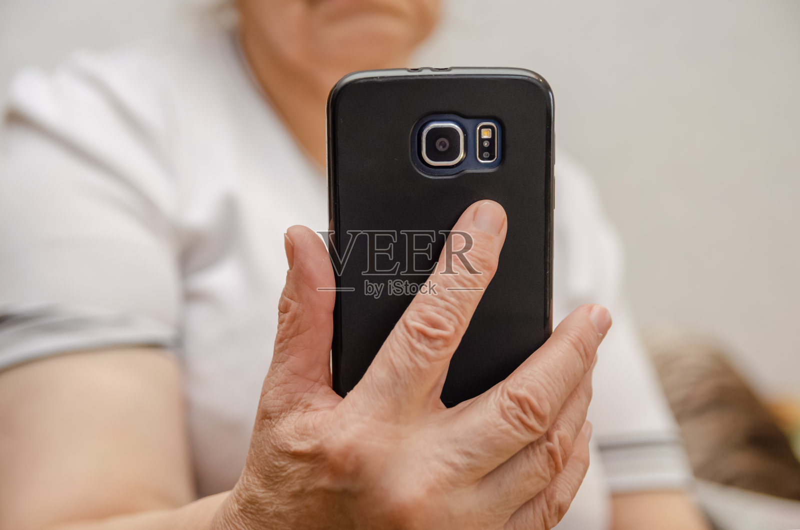 黑色的手机在一个老妇人的手中靠近照片摄影图片