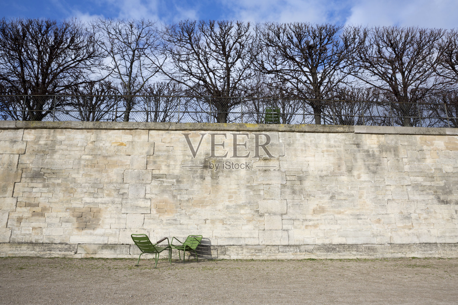 冬天的巴黎杜伊勒里宫花园，有石墙和空椅子照片摄影图片