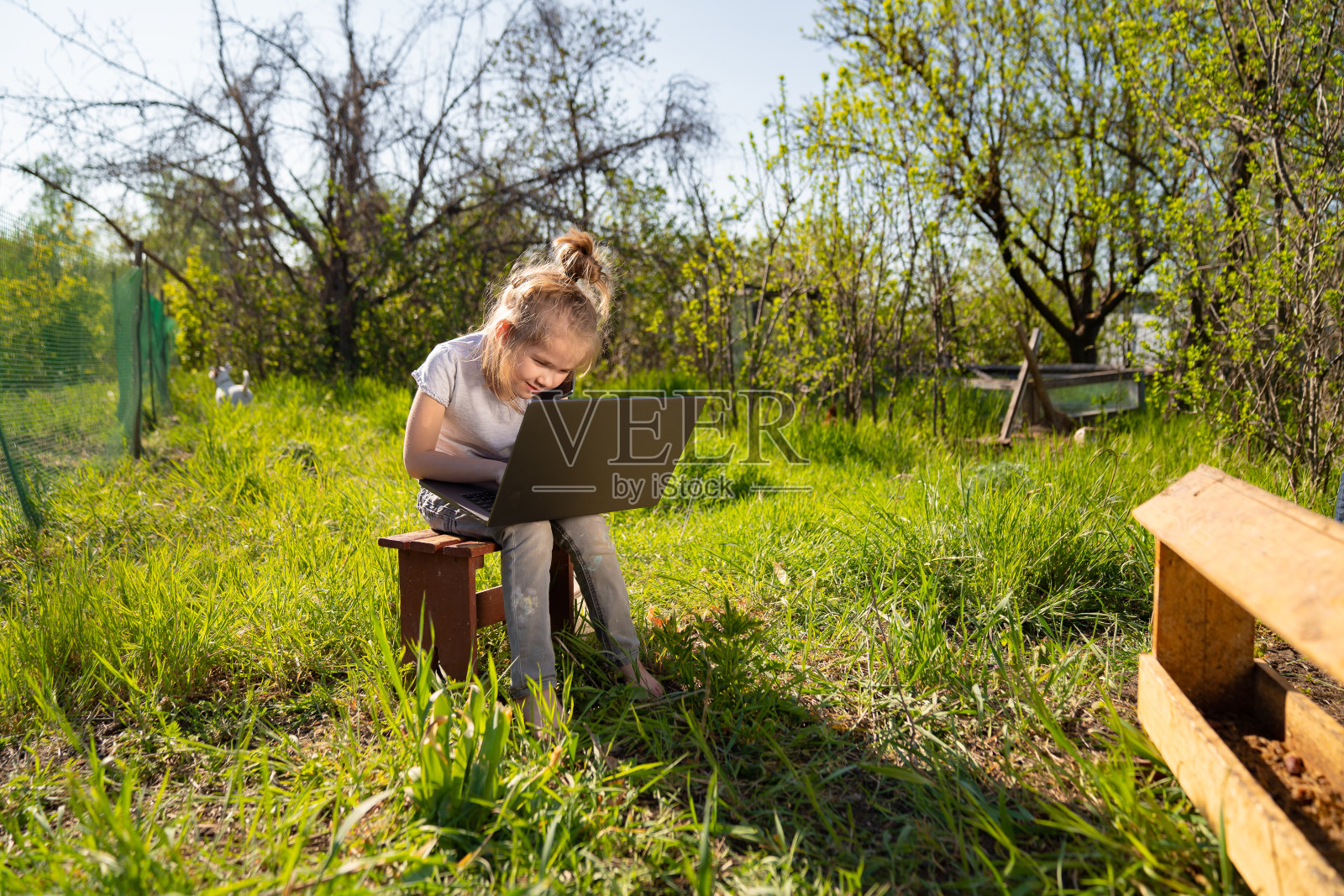 小女孩在村里用笔记本电脑打电话照片摄影图片