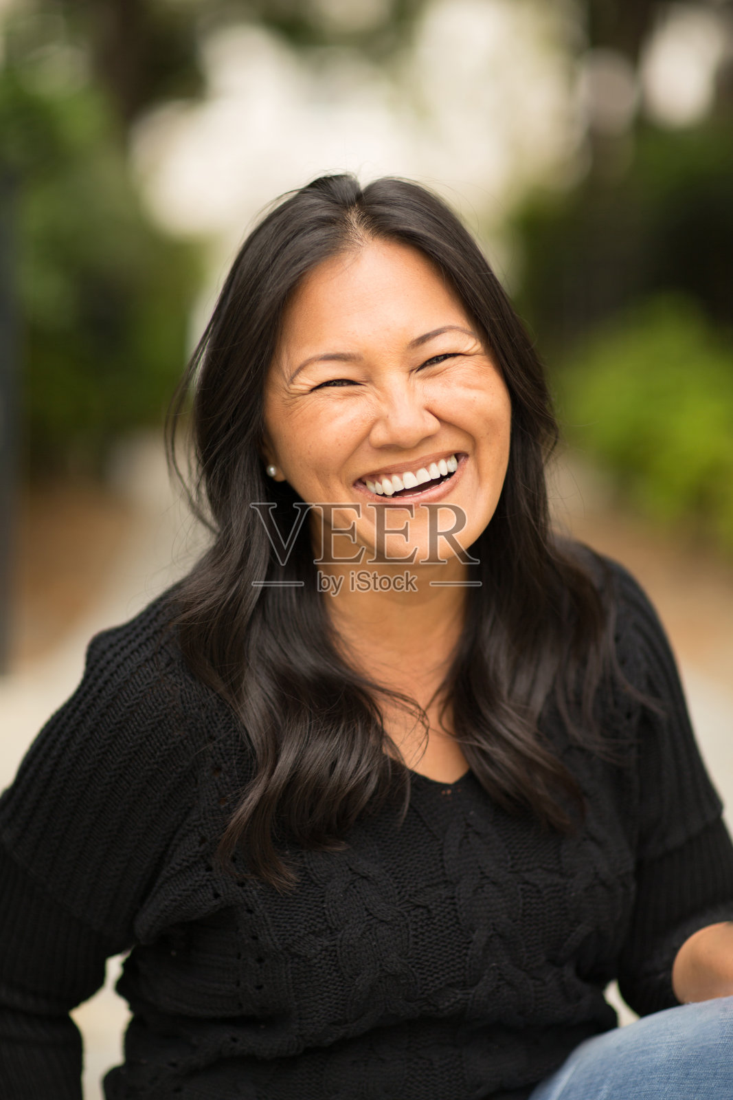 一个坐在外面的亚洲女人的肖像。照片摄影图片