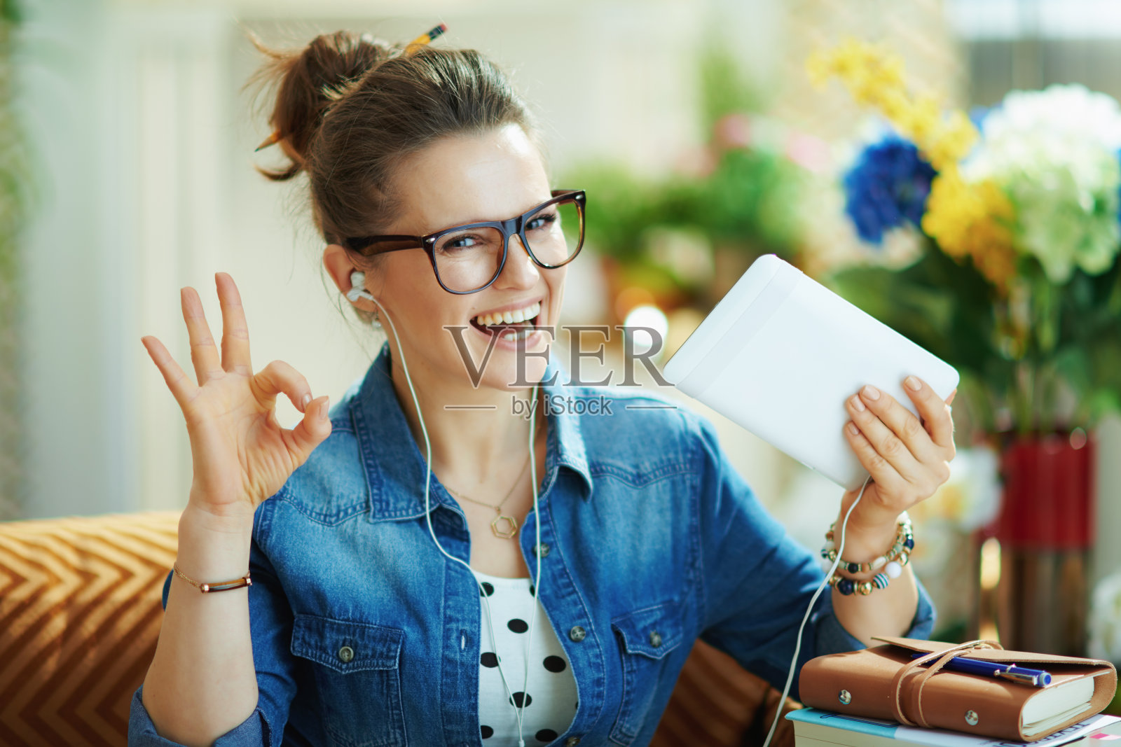 戴着白色耳机和平板电脑的快乐女人照片摄影图片