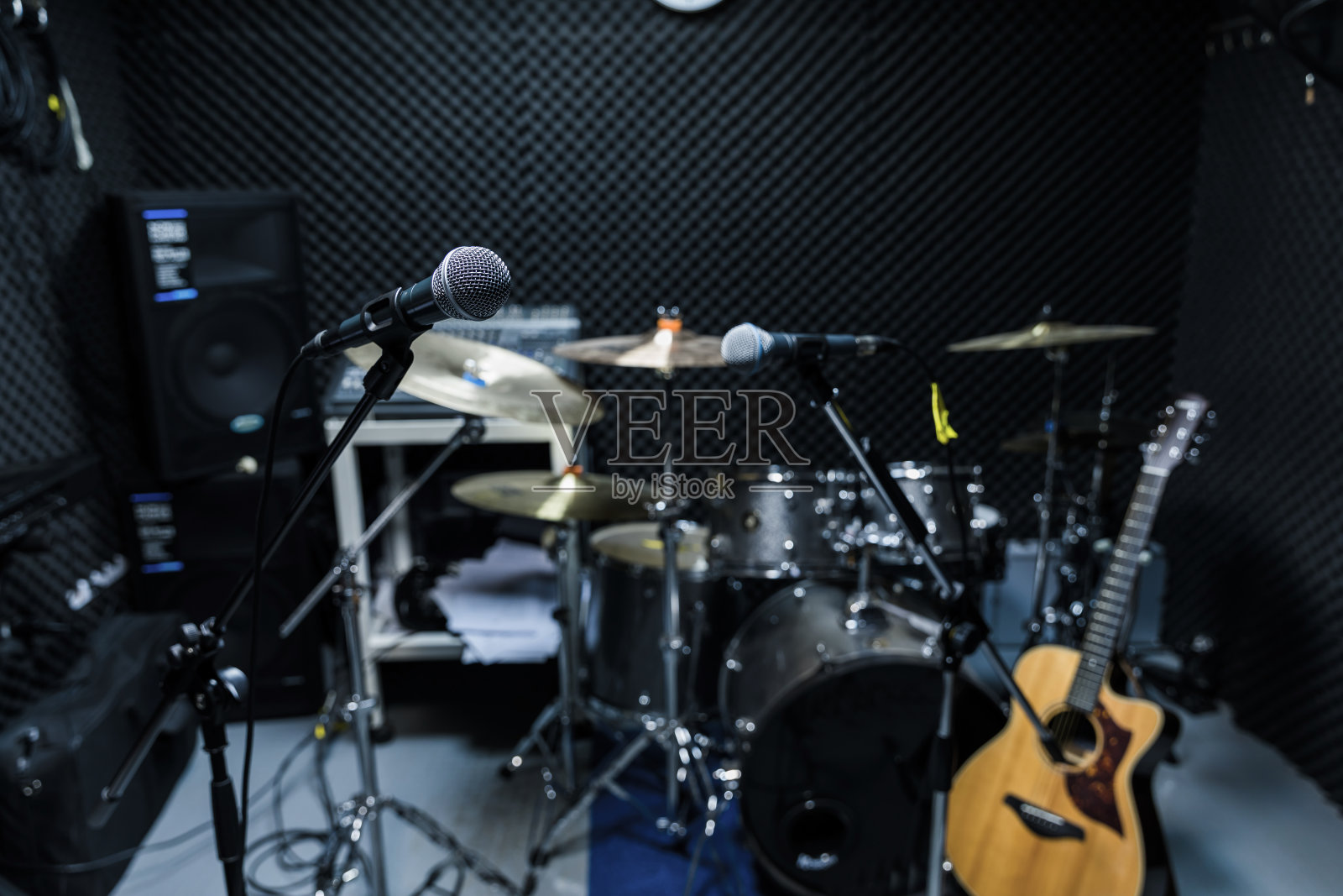 专业电容录音室麦克风，音乐概念。录音，选择性对焦麦克风在电台演播室，选择性对焦麦克风和模糊音乐设备吉他，低音，鼓钢琴背景。照片摄影图片