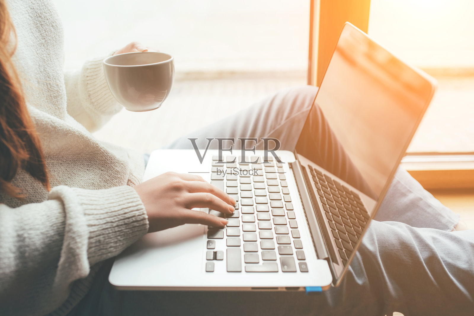 一位年轻女子在家里用笔记本电脑看新闻。照片摄影图片