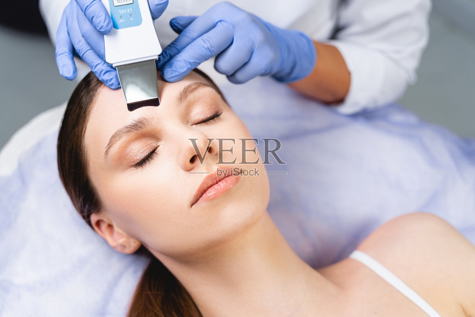 女性美容师使用超声波皮肤刮刀照片摄影图片