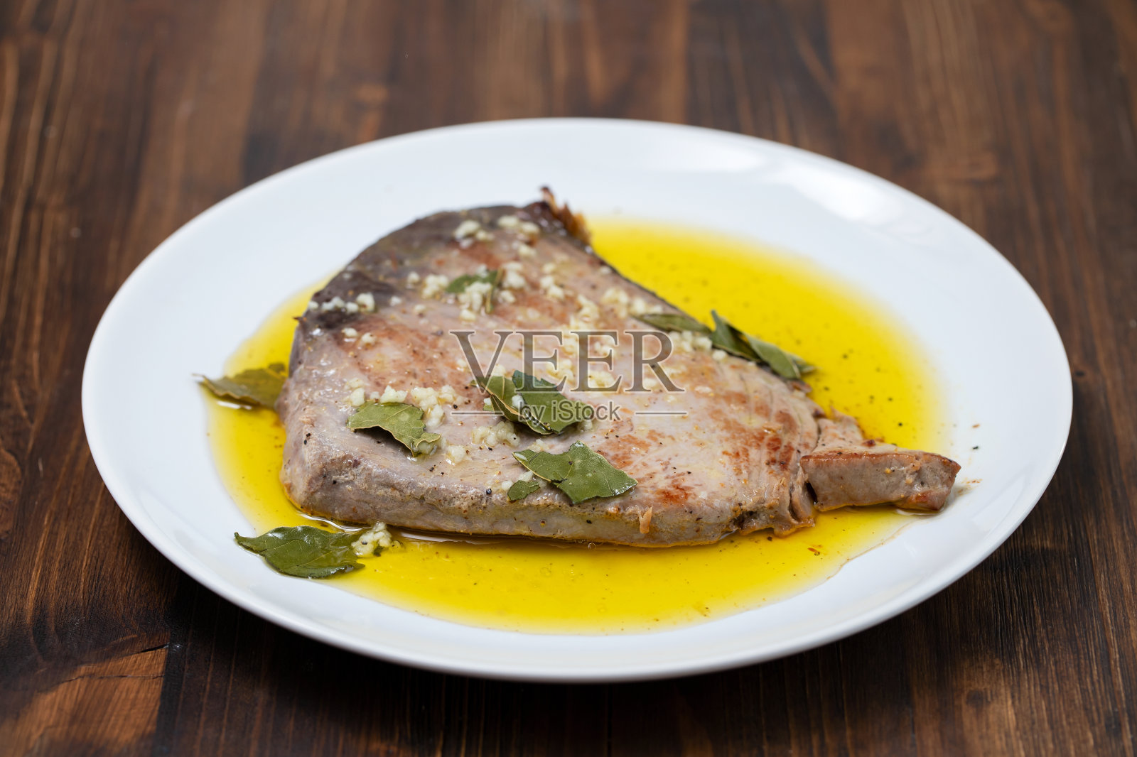 用大蒜、月桂叶和橄榄油煎金枪鱼照片摄影图片