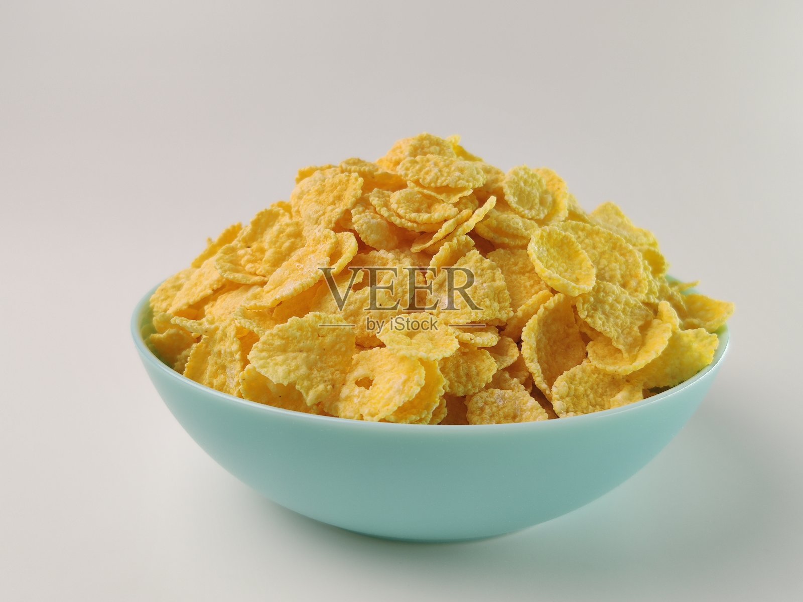 蓝色的碗里盛满了美味的麦片。健康的早餐照片摄影图片