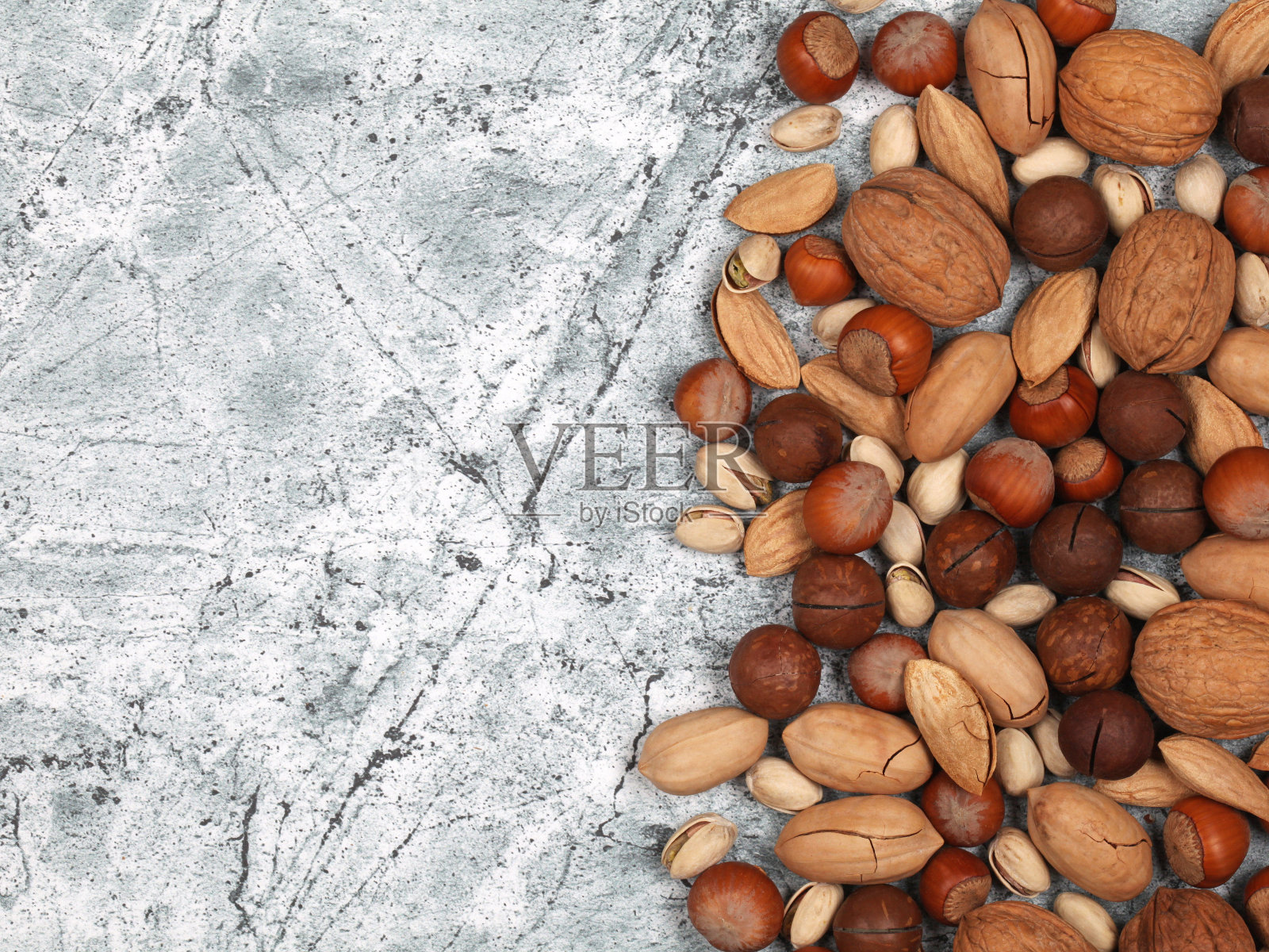在灰色的石头背景上混合生壳坚果照片摄影图片