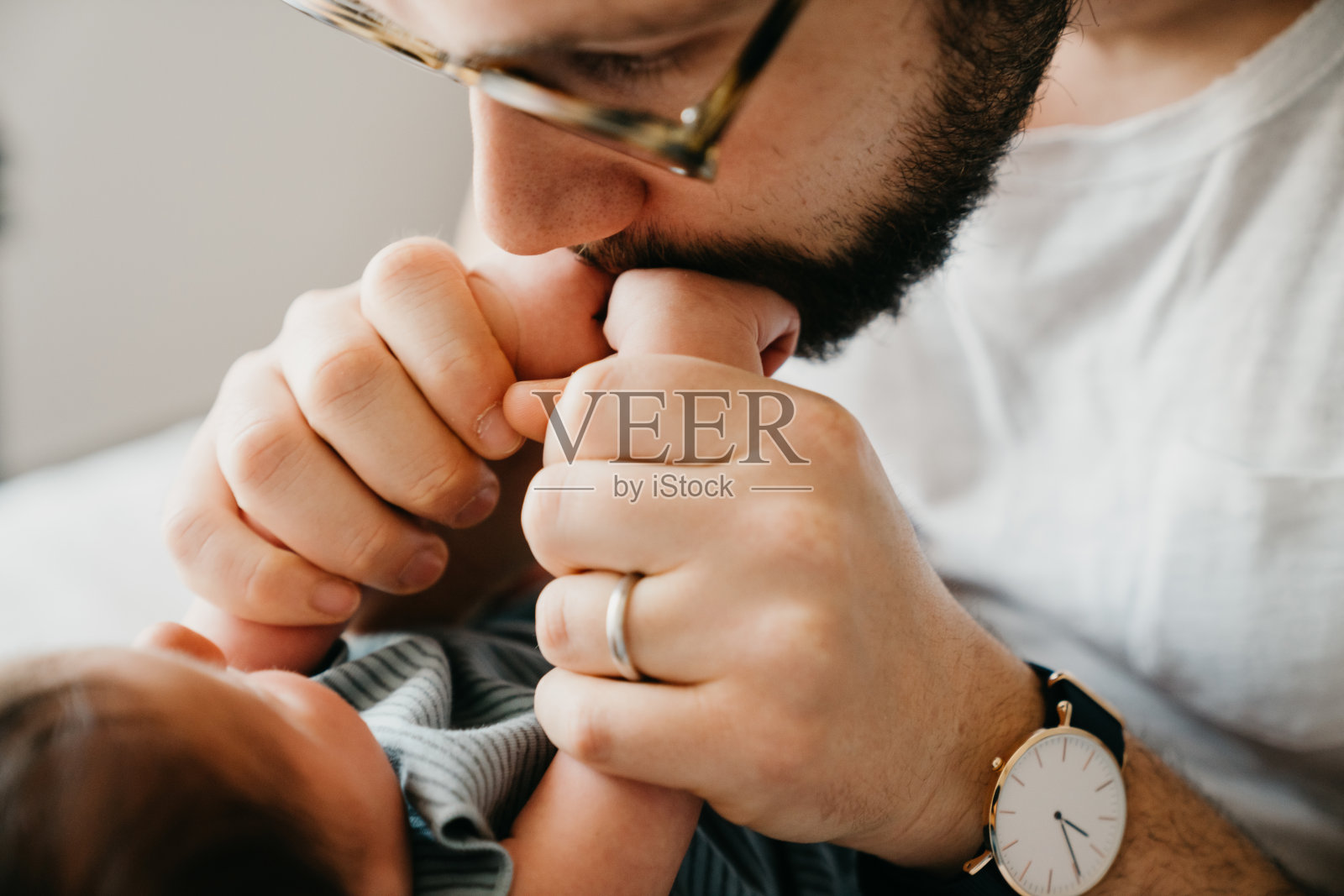 父亲正在亲吻儿子的小手照片摄影图片