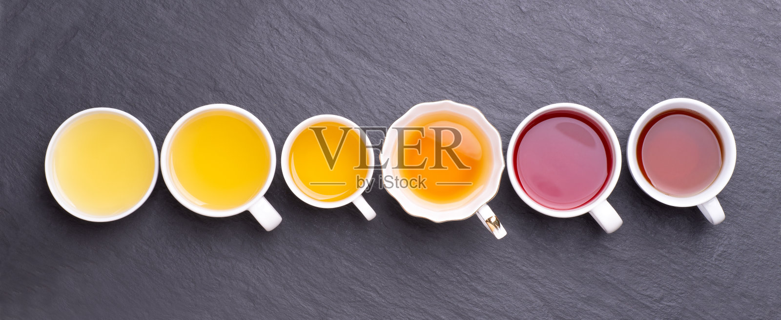 各种各样的茶杯在黑暗，石头背景，俯视图照片摄影图片