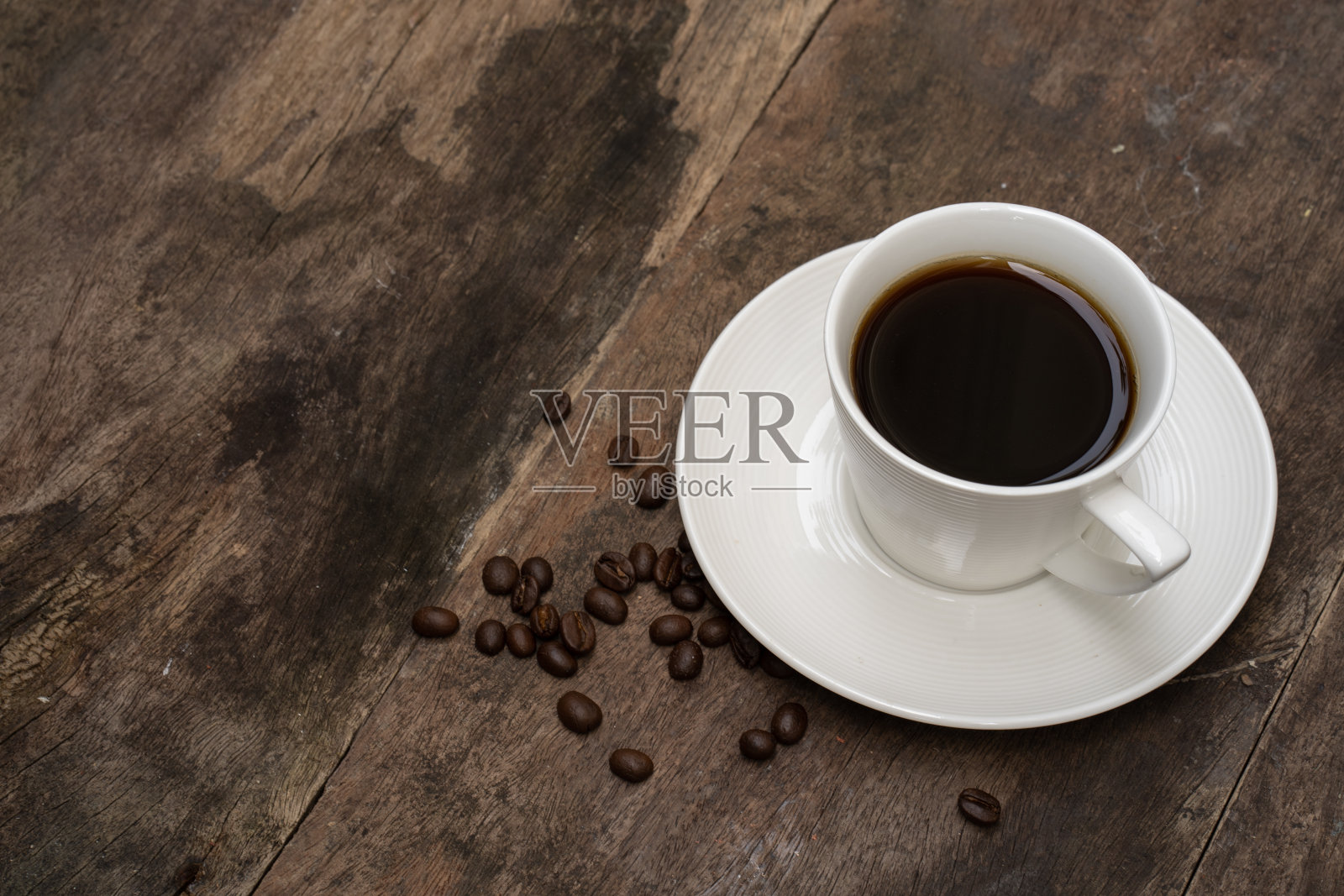 杯咖啡，在木桌上烤咖啡豆。照片摄影图片