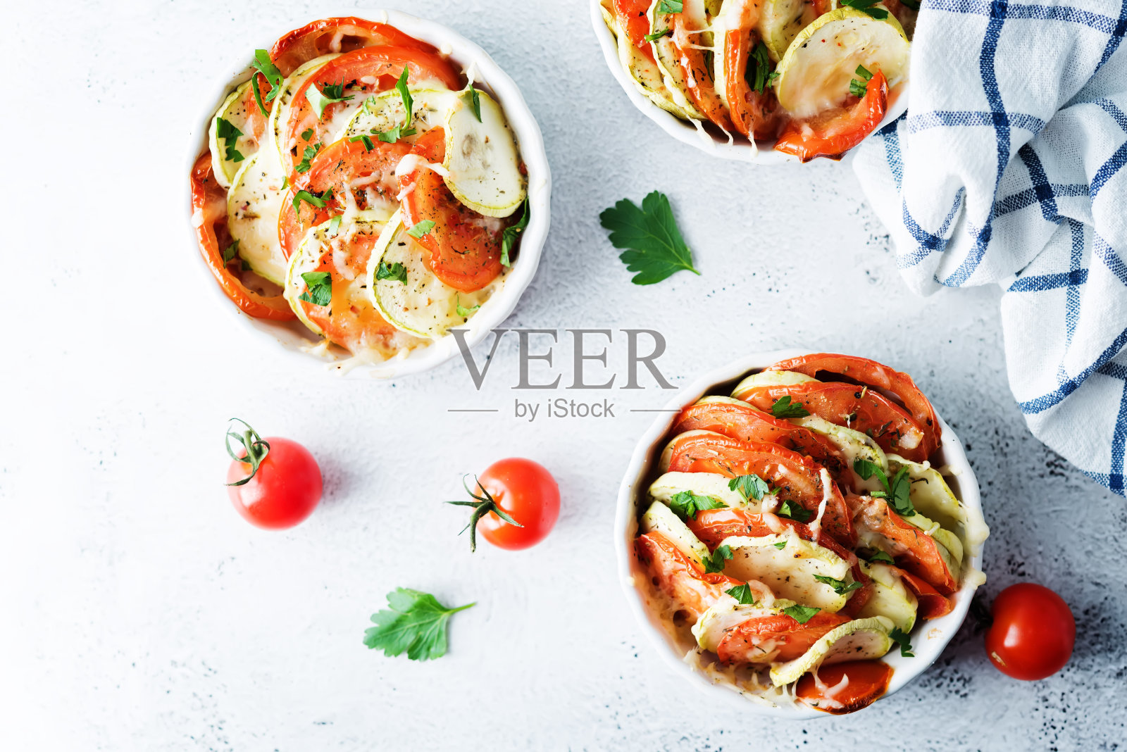 白碗西葫芦番茄砂锅，配胡椒和欧芹照片摄影图片