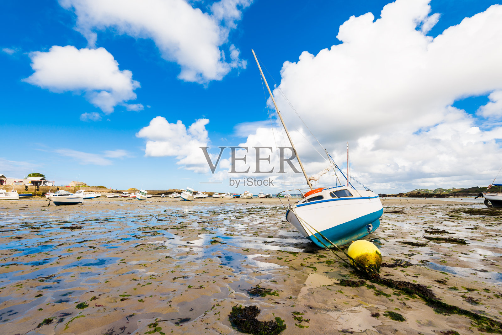 低潮期间的游艇和船只，特写。Plouguerneau、布列塔尼、法国。夏日晴空万里，蓝天白云密布照片摄影图片