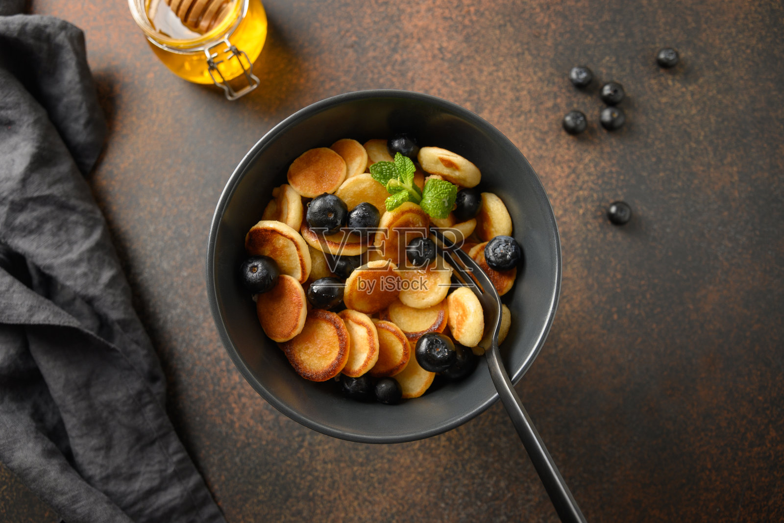 白色的桌子上放着自制的蓝莓和草莓小煎饼。从以上观点。照片摄影图片