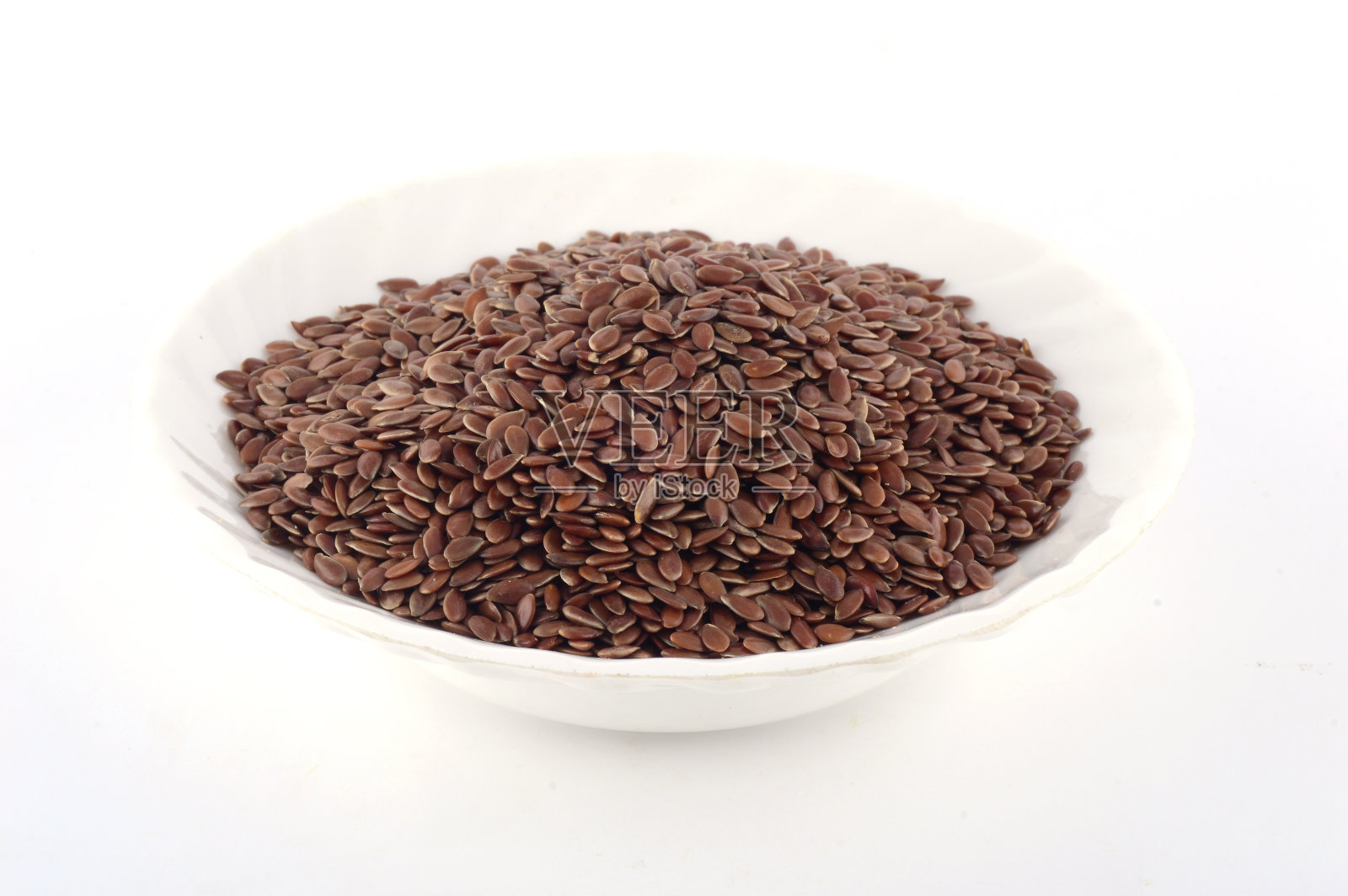 近距离观察亚麻种子在白色板孤立在白色背景照片摄影图片