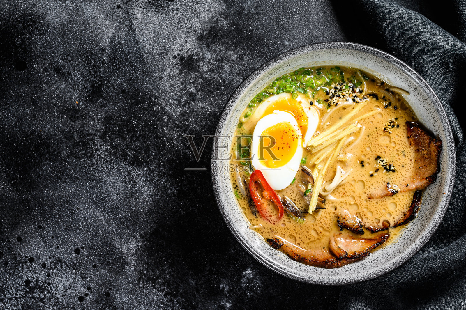 传统的日本汤拉面有肉汤，亚洲面条，紫菜，猪肉片，鸡蛋。黑色背景。前视图。本空间照片摄影图片