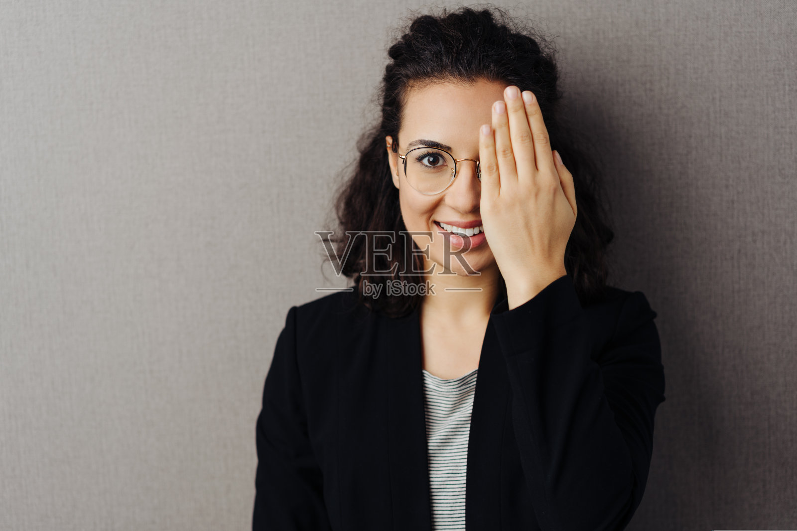 年轻女子用手遮住一只眼睛照片摄影图片