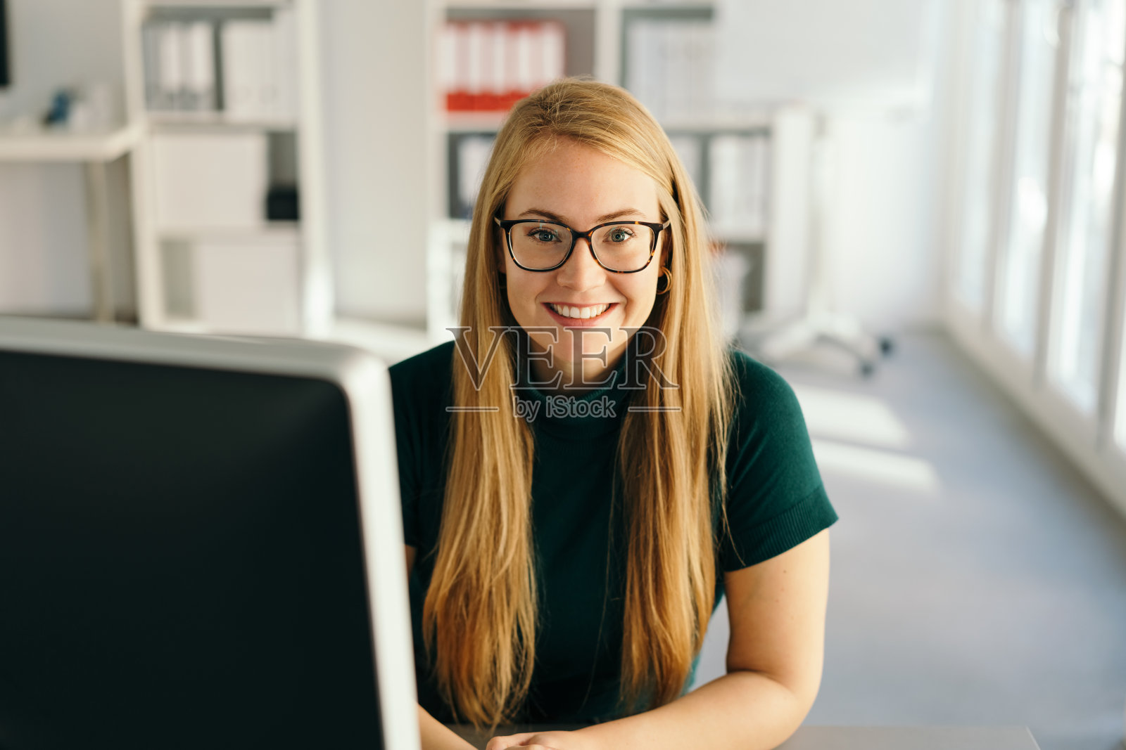 快乐的年轻的办公室职员与友好的微笑照片摄影图片