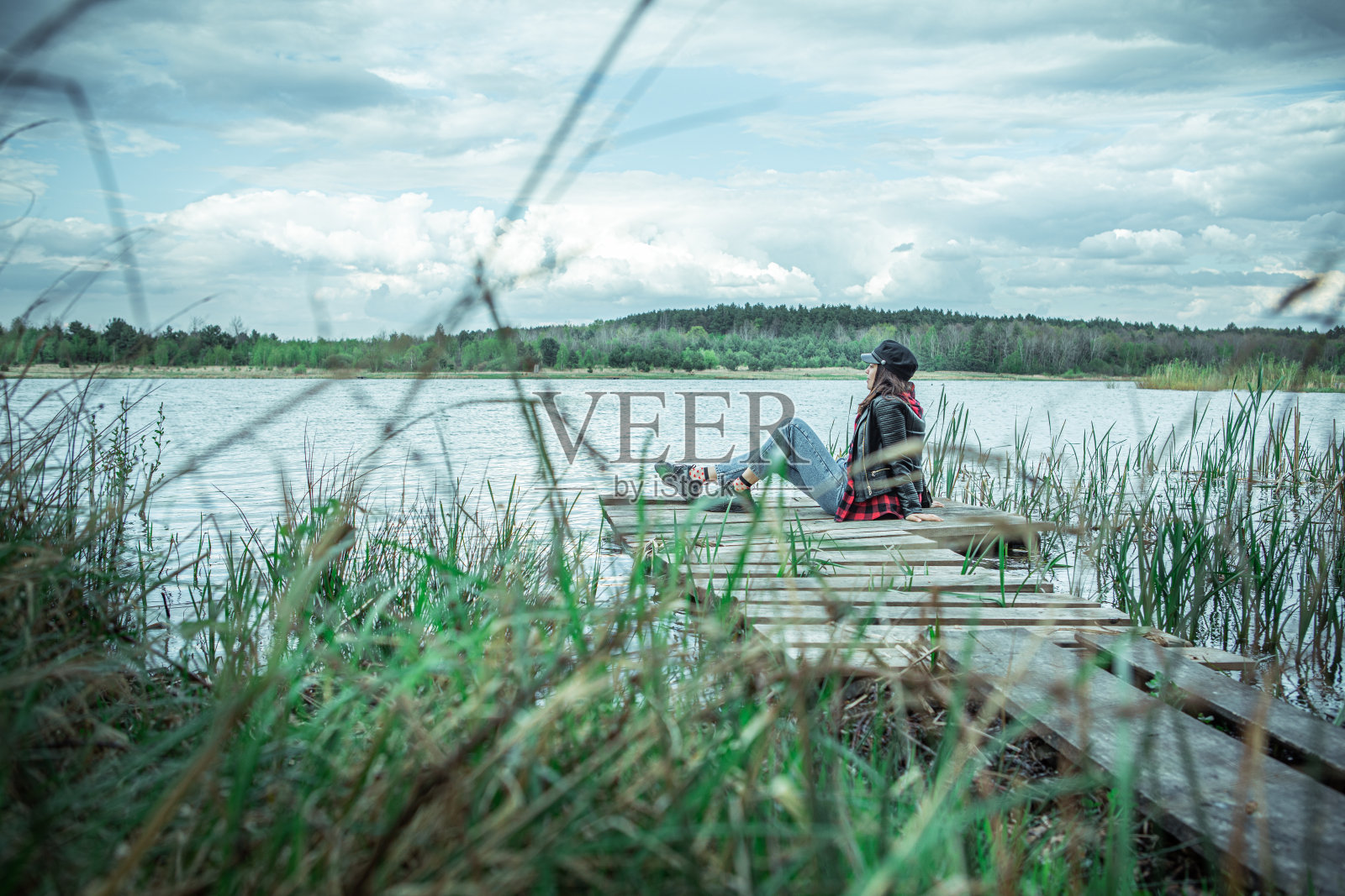 坐在木码头上欣赏湖面美景的女人照片摄影图片