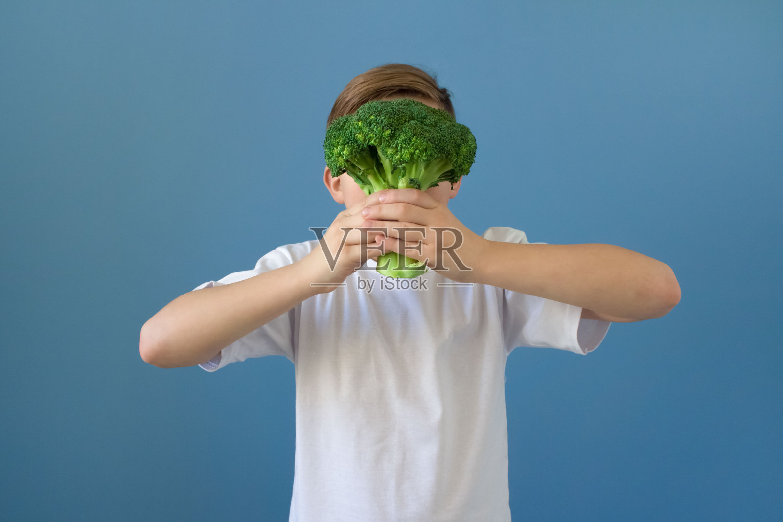 小男孩在玩新鲜的花椰菜。健康的食物照片摄影图片