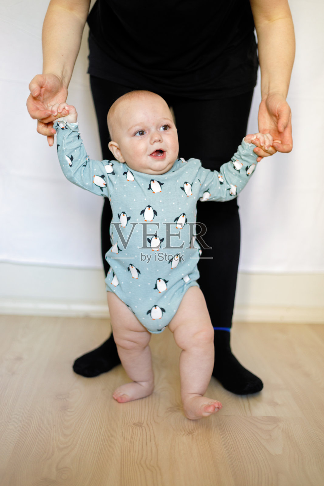 母亲帮助儿子在家里迈出第一步照片摄影图片