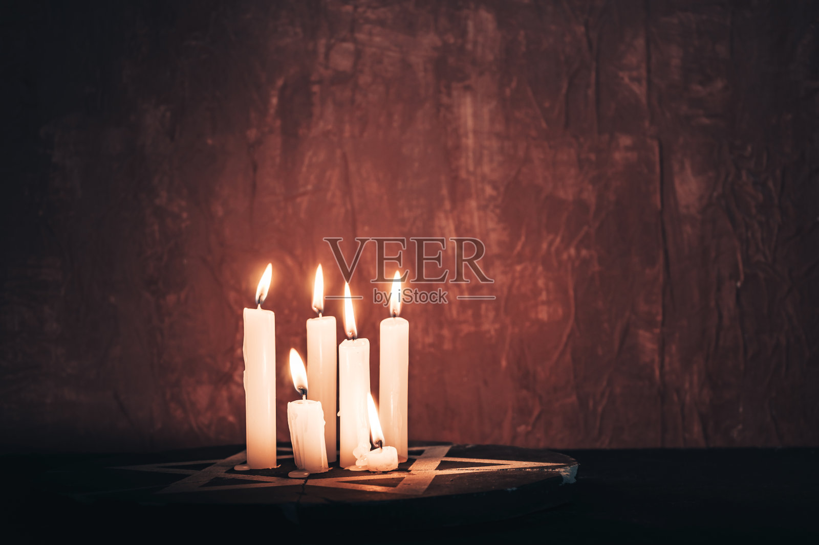 红色背景墙上的六根燃烧的蜡烛和大卫之星照片摄影图片