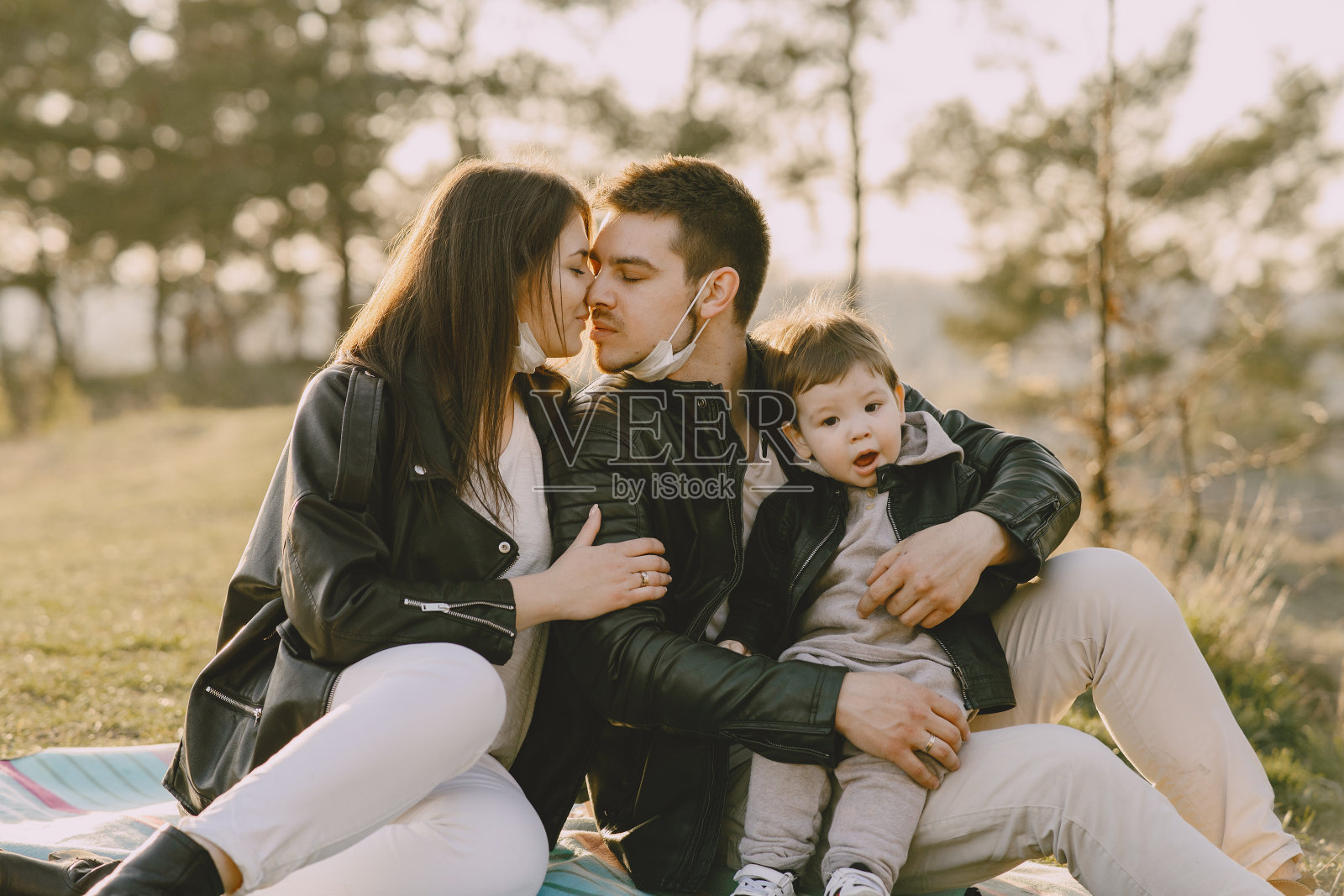 一个时尚的家庭坐在春天的田野上照片摄影图片