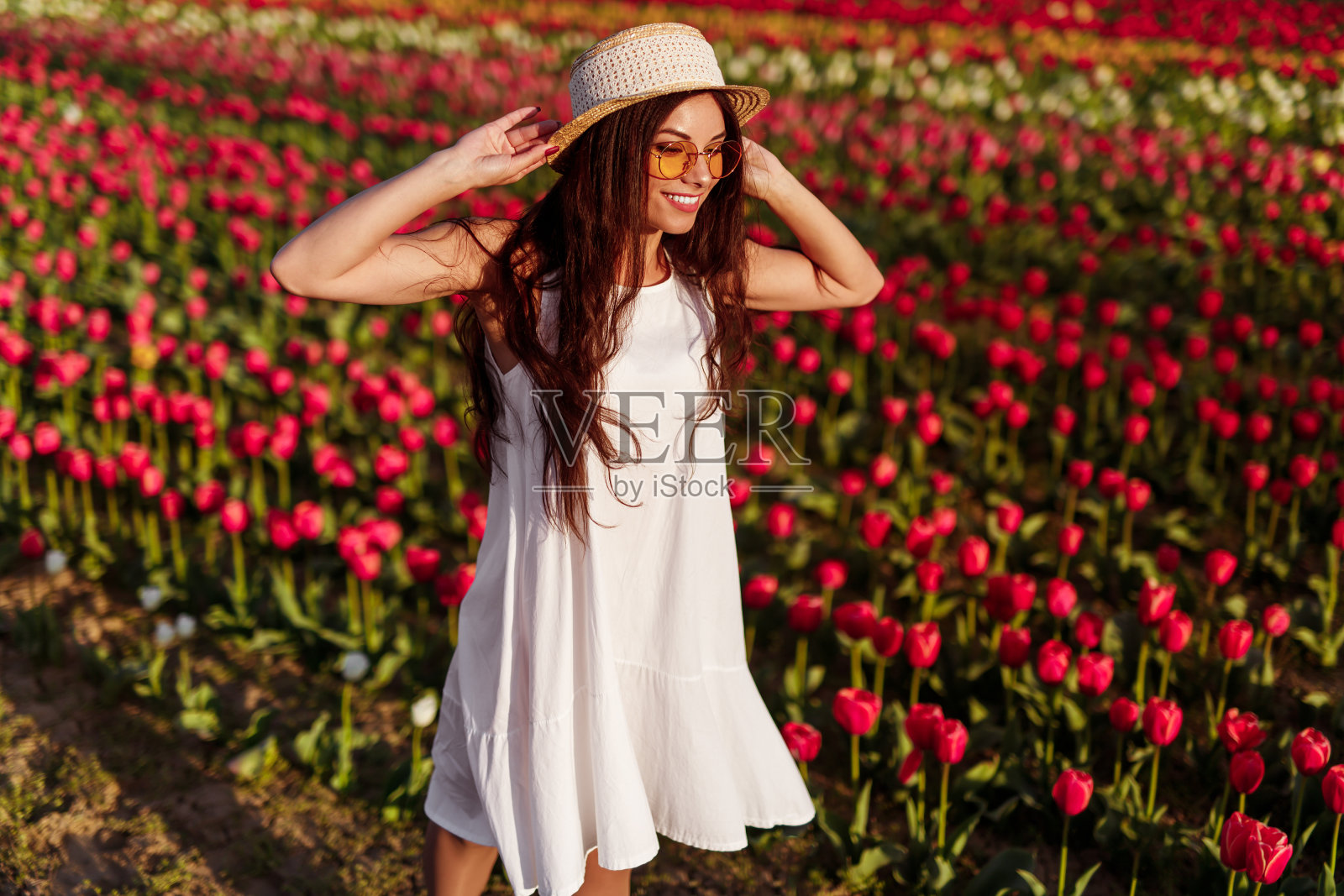 快乐的女人在郁金香地里休息照片摄影图片