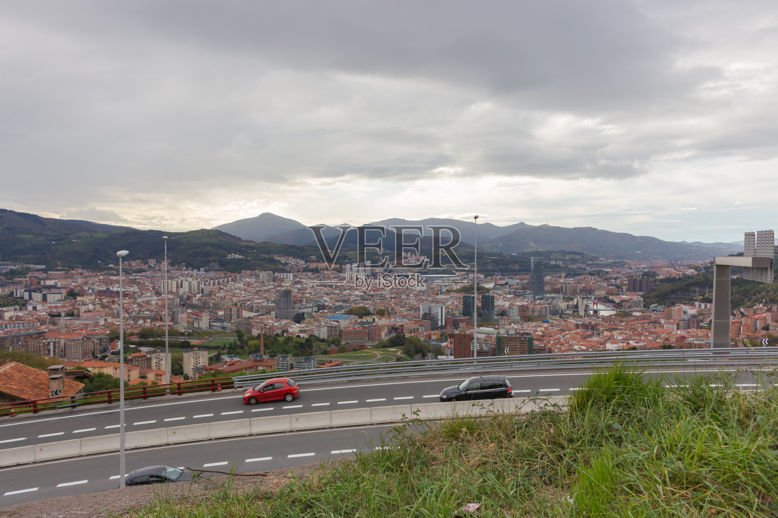 全景毕尔巴鄂地标公路和汽车。西班牙毕尔巴鄂鸟瞰图。通往西班牙巴斯克地区首都的公路。以山脉为背景的毕尔巴鄂。照片摄影图片